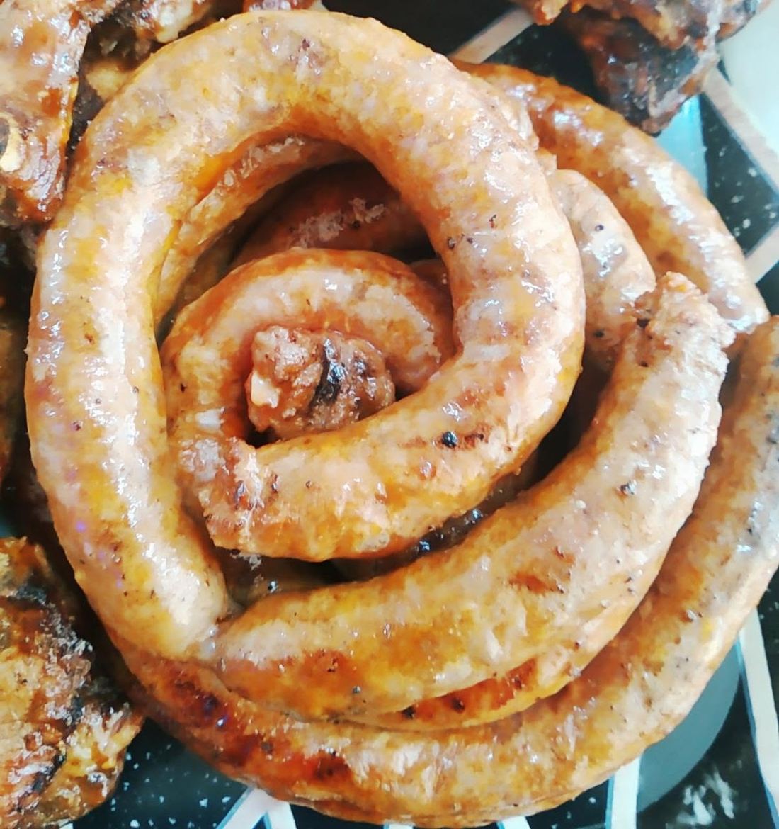 Coil of Varsity tomato sausage fresh off the braai